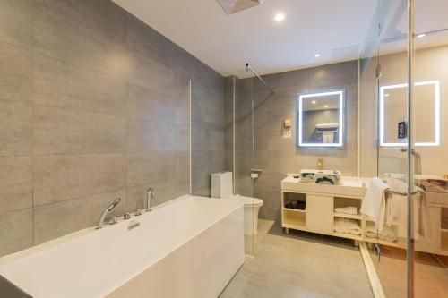 a bathroom with a white tub and a sink at Qinfu Hotel Beijing Nanluogu Lane Houhai in Beijing