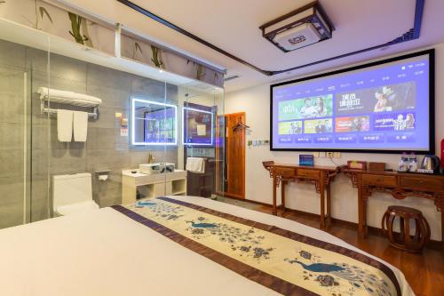 a large room with a bed and a large screen at Qinfu Hotel Beijing Nanluogu Lane Houhai in Beijing