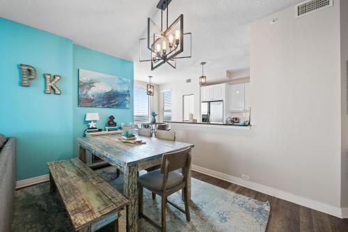 a dining room with blue walls and a table and chairs at Beach Colony East 14D in Pensacola
