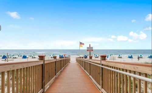 a wooden boardwalk leading to the beach with people at Beach Colony East 14D in Pensacola
