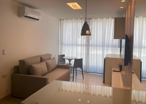 a living room with a couch and a table at Flat Porto Blue 104 - Centro Porto de Galinhas in Porto De Galinhas