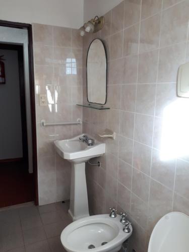 a bathroom with a sink and a toilet and a mirror at Los Picaflores in Colón