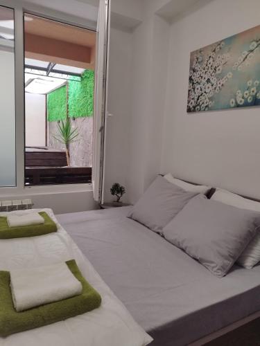 a bedroom with a large white bed with a window at Alexandria Lux Apartments in Karpoš Dva
