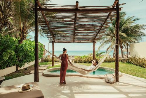 two women in a hammock by a pool at Viceroy Riviera Maya, a Luxury Villa Resort - Adults Only in Playa del Carmen