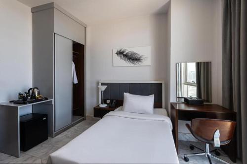 a bedroom with a bed and a desk and a chair at HDB Al Sahafa in Riyadh