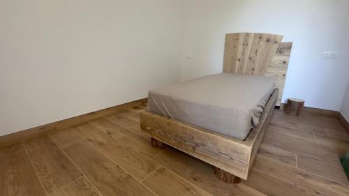 a bedroom with a bed on a wooden floor at Appartamenti Ai 7 nani in Peron