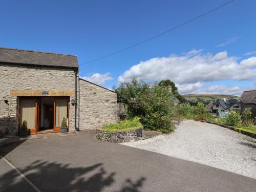 a stone building with a driveway in front of it at Town End Barn in Bradwell