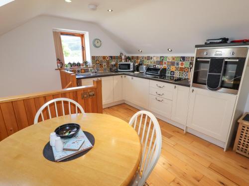a kitchen with a wooden table and a wooden floor at Town End Barn in Bradwell