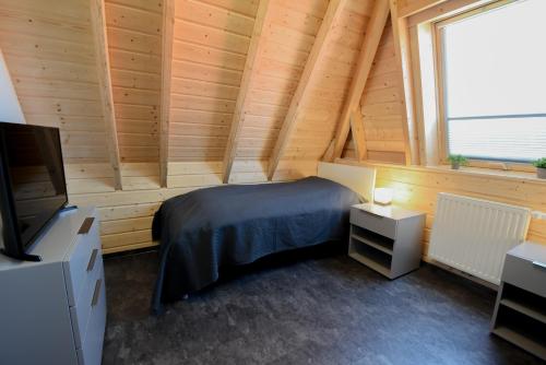 a bedroom with a bed and a tv in a room at Ferienhaus Mellumplate 23 in Dorum Neufeld