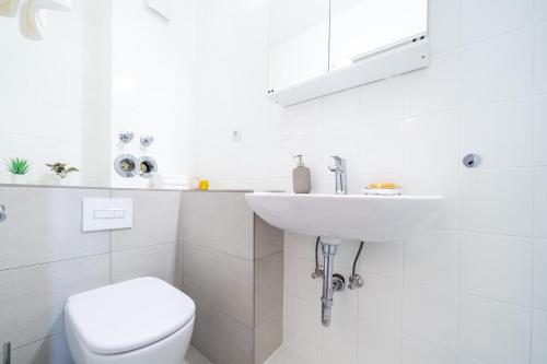 a white bathroom with a toilet and a sink at Appartement "Wattenruh" Cappel Whg 4 in Cappel-Neufeld