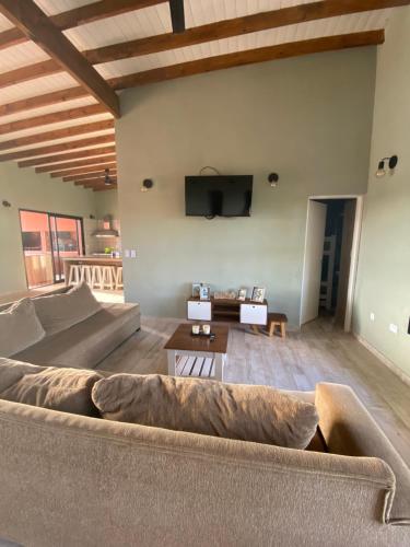 Una sala de estar con un sofá y un televisor de pantalla plana. en Terramar, en Las Toninas