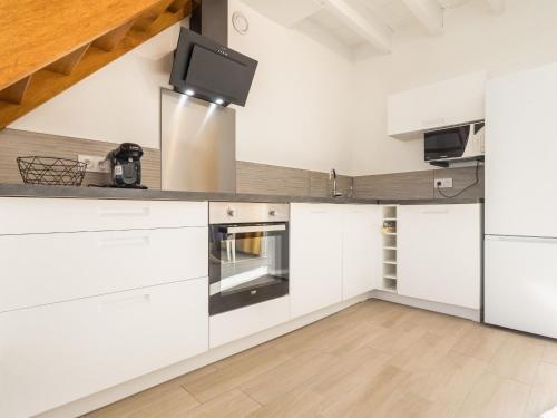 une cuisine avec des armoires blanches et un plancher en bois dans l'établissement Maison de Ville à La Montagne avec Wifi, Animaux admis, Proche Nantes - FR-1-306-1286, à La Montagne