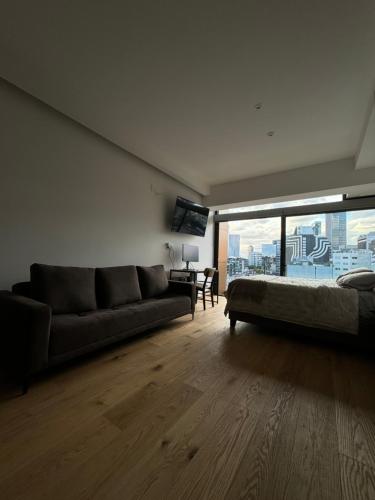 a living room with a couch and a large window at Luxury Apartment in Roma Norte With Stunning Views in Mexico City