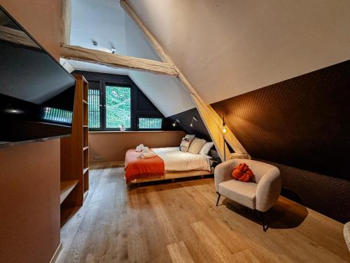 a bedroom with a bed and a chair in a room at Hôtel Le Manoir in Marche-en-Famenne
