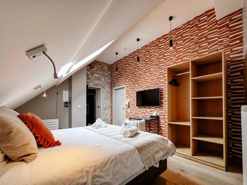a bedroom with a brick wall and a bed at Hôtel Le Manoir in Marche-en-Famenne