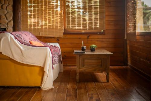 a room with a bed and a table and a window at En calma in Punta Del Diablo