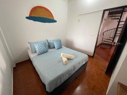 a bedroom with a bed with a towel on it at Hostel La Hormiga Barichara in Barichara
