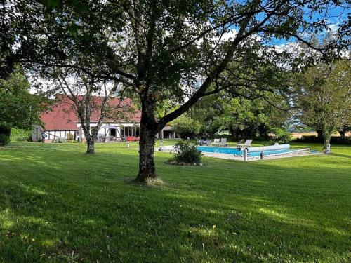 un parc avec un arbre et une piscine dans l'établissement Secret Escape, à Gardefort