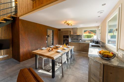 - une cuisine avec une grande table en bois dans l'établissement Chalet némésia avec spa à Gérardmer, à Gérardmer