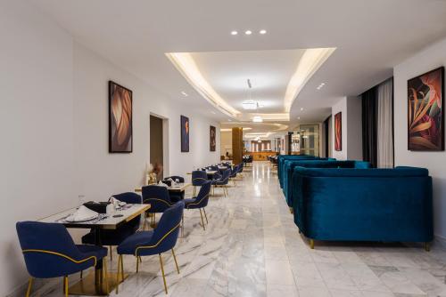 a dining room with blue chairs and tables at HDB Al Sahafa in Riyadh