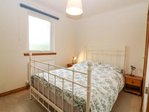 ein Schlafzimmer mit einem Bett und einem Fenster in der Unterkunft Hedgehogs Cottage in Glenrothes
