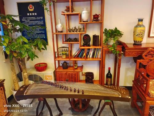 a room with a table and a shelf with vases at Qinfu Hotel Beijing Nanluogu Lane Houhai in Beijing