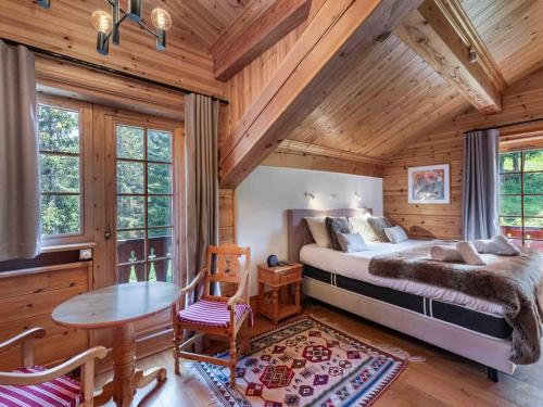 a bedroom with a bed and a table in a room at Chalet savoyard de caractère avec sauna et cheminée à Courchevel 1650 - FR-1-563-17 in Courchevel