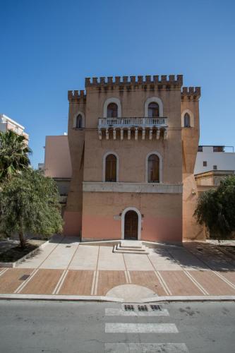 a brick building with a balcony on top of it at ControVento Rooms in Margherita di Savoia