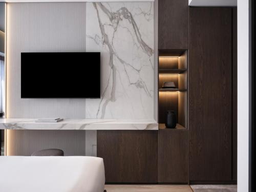 a living room with a tv on a wall at Nur Edge Aparthotel - Acropolis Skyline in Athens