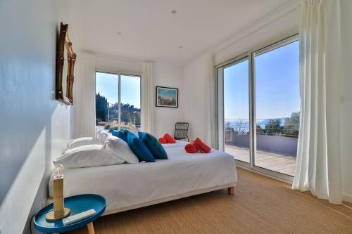 une chambre avec un grand lit avec une grande fenêtre dans l'établissement Villa DADOU, à Cassis
