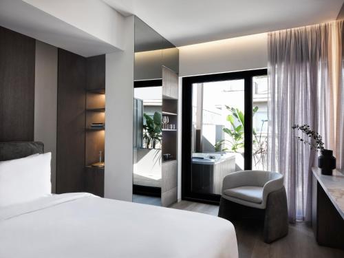 a bedroom with a bed and a bathroom with a tub at Nur Edge Aparthotel - Acropolis Skyline in Athens