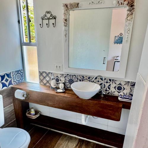 a bathroom with a sink and a mirror at JaParaíso Pousada Ateliê in Japaratinga