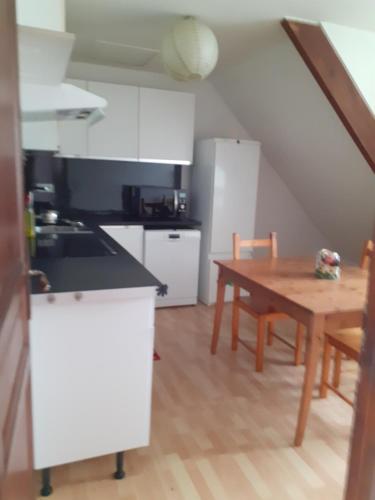 une cuisine avec une table en bois et une table ainsi qu'une salle à manger dans l'établissement Appartement prés du Park de champigny sur Marne, à Champigny-sur-Marne