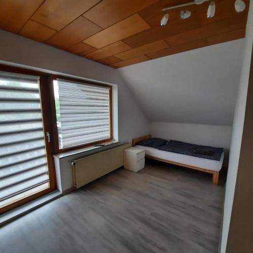 a bedroom with a bed and two large windows at LivingRoom GmbH Raf1 Apartment in Salzgitter und Umgebung in Salzgitter