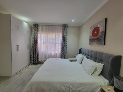 a bedroom with a large bed and a window at Sable Suites C1, 1 Bed Apartments in Kabulonga in Lusaka