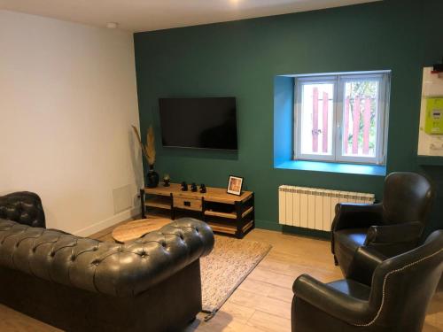 a living room with two leather chairs and a television at Charmante maison in Château-Gontier