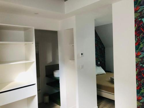 a room with white shelves and a bed at Charmante maison in Château-Gontier