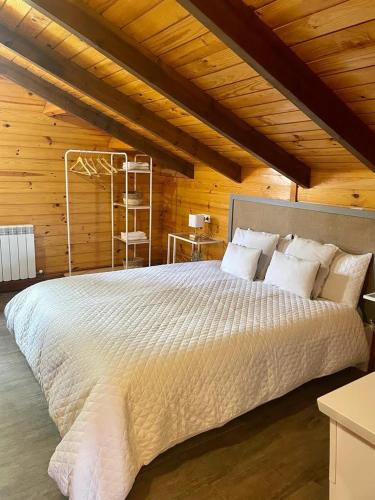 a bedroom with a large bed in a wooden room at Villa Independiente con Bodega y Barbacoa - perfecto familia y grupos in Alacón