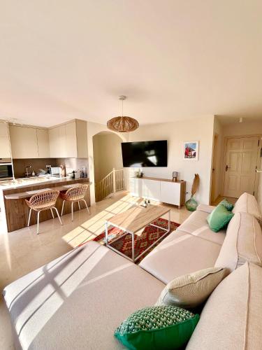 a living room with a white couch and a kitchen at Sea view duplex private jacuzzi, garden, terras and shared pool in Palm-Mar