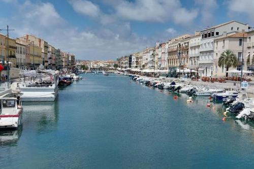 une rivière avec des bateaux amarrés dans une ville avec des bâtiments dans l'établissement Centre ville vue St Clair, à Sète
