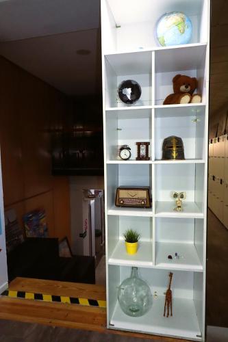 a white book shelf with various items on it at Madrid Downtown Hostel in Madrid
