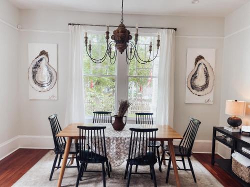 a dining room with a table with chairs and a chandelier at Guesthouse on Girod in Mandeville