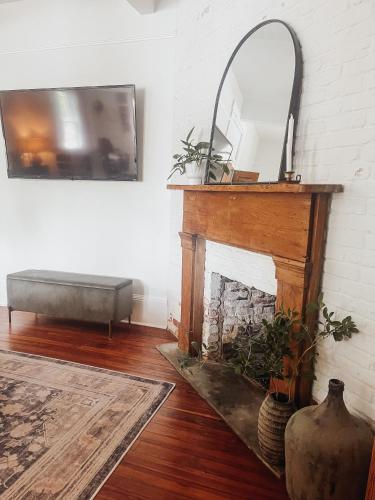 a living room with a fireplace and a mirror at Guesthouse on Girod in Mandeville