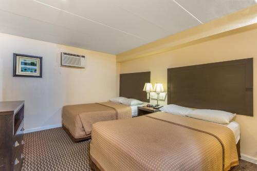 Habitación de hotel con 2 camas y TV en Travelodge by Wyndham Suites Virginia Beach Oceanfront, en Virginia Beach