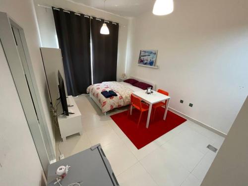 a bedroom with a bed and a red rug at Studio Apartment, close to beach and sunset views in Umm Al Quwain