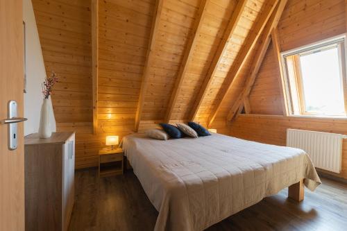 a bedroom with a bed in a wooden cabin at Ferienhaus Mellumplate 52 in Dorum Neufeld