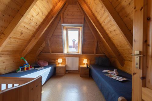 Zimmer im Dachgeschoss mit 2 Betten und einem Fenster in der Unterkunft Ferienhaus "Familie Haupt" Mellumplate 48 in Dorum Neufeld