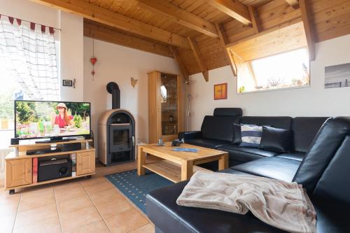 a living room with a couch and a tv at Ferienhaus "Moby Dick" Mellumplate 44 in Dorum Neufeld