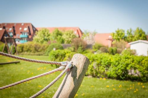 a rope tied to a wooden post in a yard at Ferienhaus "Moby Dick" Mellumplate 44 in Dorum Neufeld