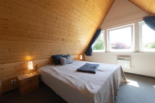 a bedroom with a bed in a wooden wall at Ferienhaus Nordertill 01 in Dorum Neufeld